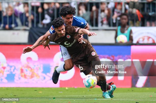 Elias Saad of FC St. Pauli is challenged by Guilherme Ramos of DSC Arminia Bielefeld during the Second Bundesliga match between FC St. Pauli and DSC...