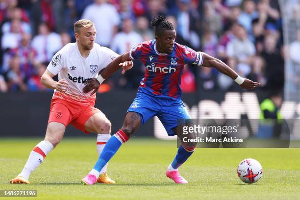 Wilfried Zaha of Crystal Palace holds off Jarrod Bowen of West Ham United during the Premier League match between Crystal Palace and West Ham United...
