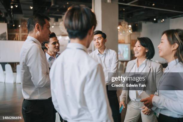 アジアの多民族ビジネスマンがセミナービジネス会議のコーヒーブレイクで語る - surrounding ストックフォトと画像