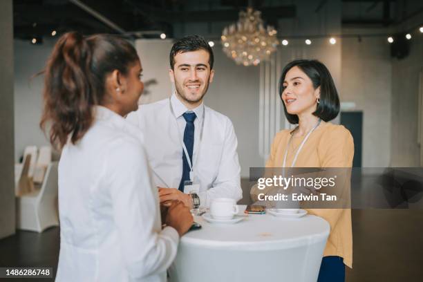 asiatische multiethnische geschäftsleute unterhalten sich während einer kaffeepause im seminar business-konferenz - lanyard man stock-fotos und bilder