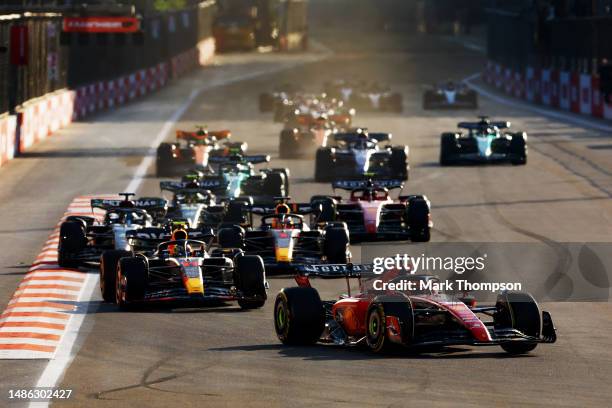 Charles Leclerc of Monaco driving the Ferrari SF-23 leads Sergio Perez of Mexico driving the Oracle Red Bull Racing RB19 at the restart during the...