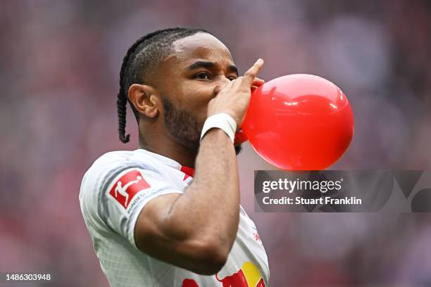 Christopher Nkunku of RB Leipzig celebrates with a balloon after scoring their sides first goal during the Bundesliga match between RB Leipzig and...