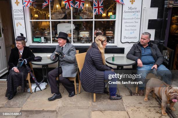 Couple in gothic clothing sit in a pavement cafe during the Whitby Goth Weekend on April 29, 2023 in Whitby, England. The original Whitby Goth...