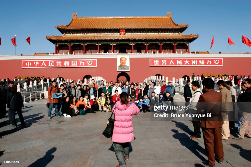 A group of tourists having their picture taken in front of Tiananmen, the Gate of Heavenly Peace.