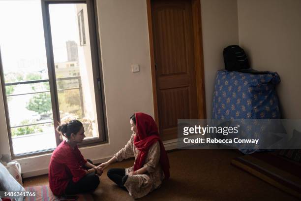 Afghan refugee Muzhgan and who fled Afghanistan after the fall of Kabul in 2021, talks with her roommate at a guesthouse run by the Future Brilliance...