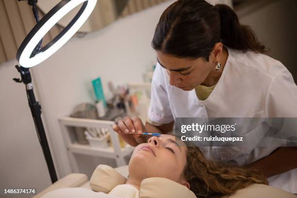 young woman during eyebrow lamination procedure - brow lamination stock pictures, royalty-free photos & images