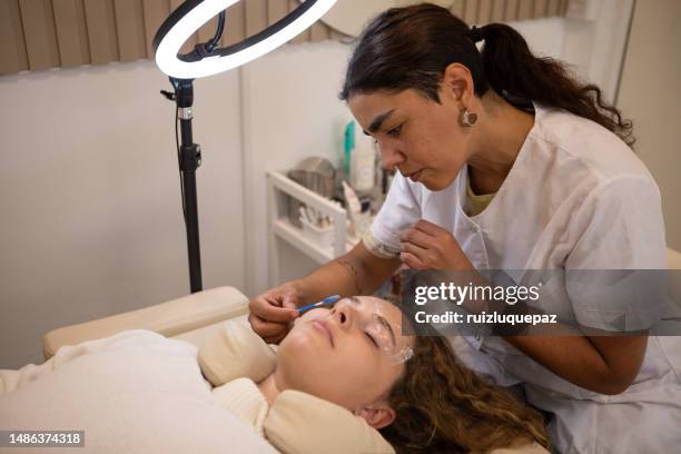 young woman during eyebrow lamination procedure - brow lamination stock pictures, royalty-free photos & images