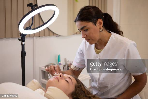 young woman during eyebrow lamination procedure - brow lamination stock pictures, royalty-free photos & images
