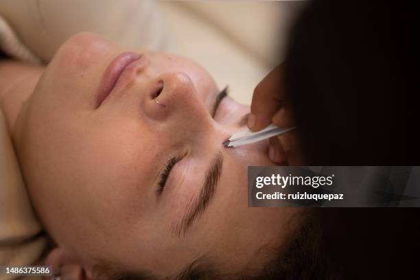 young woman during eyebrow lamination procedure - brow lamination stock pictures, royalty-free photos & images