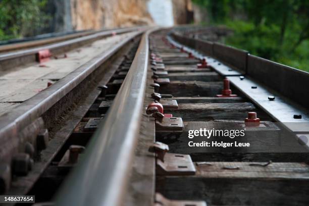 close-up of rail tracks on wooden trestle viaduct of trans-river kwai death railway at saphan tham krasae, near kanchanaburi. - railroad track stock-fotos und bilder