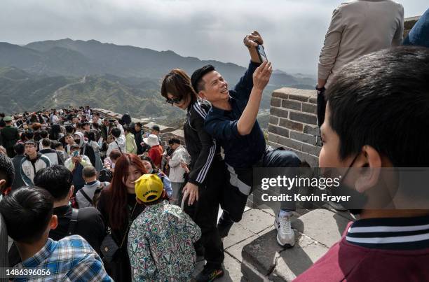 Man takes pictures in a crowded area on the Great Wall during a visit to the popular tourist site on the first day of the May Labour Day holiday on...