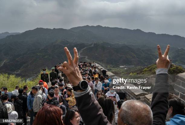 Man gestures as he and other visitors walk on the Great Wall during a visit to the popular tourist site on the first day of the May Labour Day...