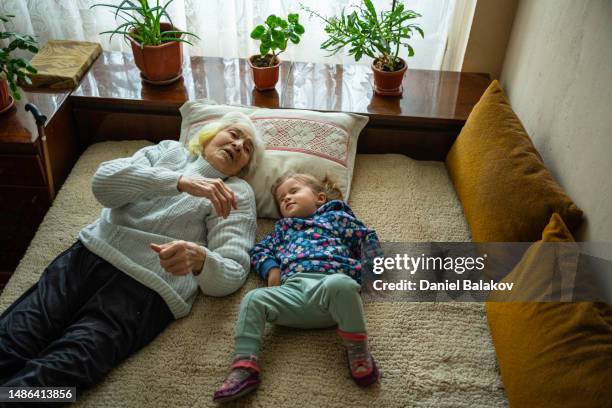 grandma and girl taking a nap at home. - grandma sleeping stockfoto's en -beelden