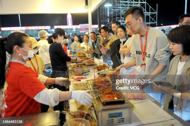 Tourists enjoy a barbecue feast at a gourmet marketplace during the five-day May Day Holiday on April 29, 2023 in Zibo, Shandong Province of China.