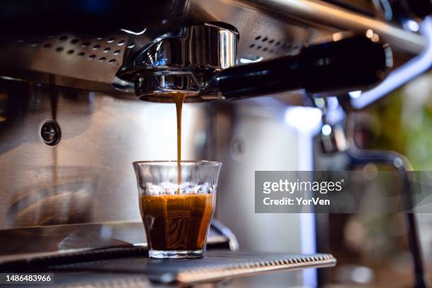 gouttes d’espresso dégoulinant du porte-filtre dans un petit café - americano photos et images de collection