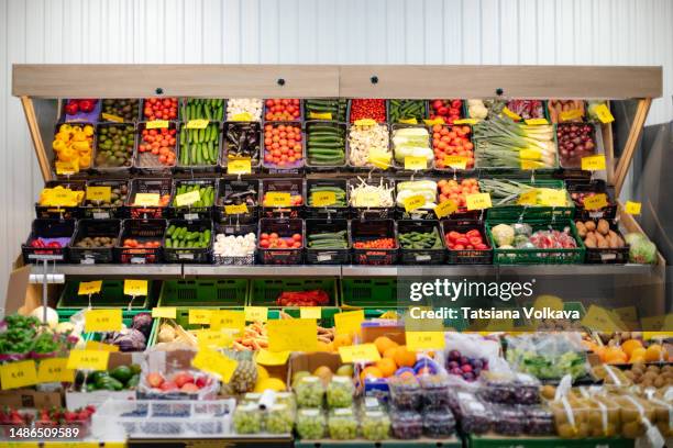 fresh fruits, vegetables and berries laying out in fresh produce stall - pflanzliche ernährung stock-fotos und bilder