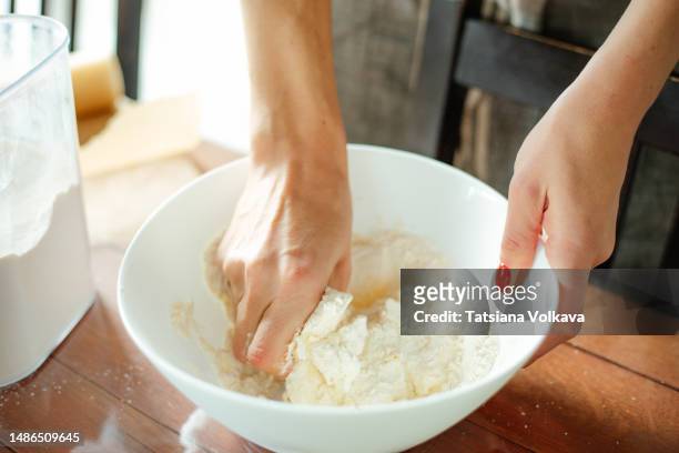hands of unrecognizable white woman cooking dough in big white bowl - sifting stock photos et images de collection