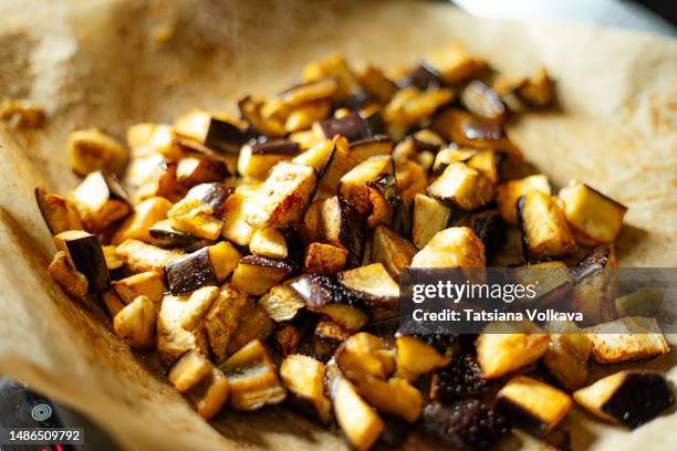 close up of baked eggplant pieces placed on brown parchment paper - inzoomen stockfoto's en -beelden