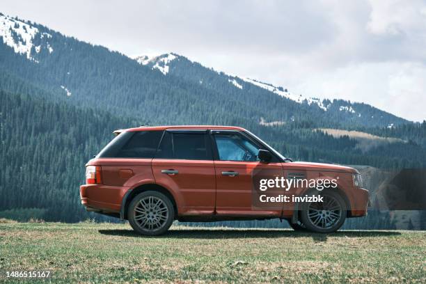red suv in the mountains - range rover stock pictures, royalty-free photos & images