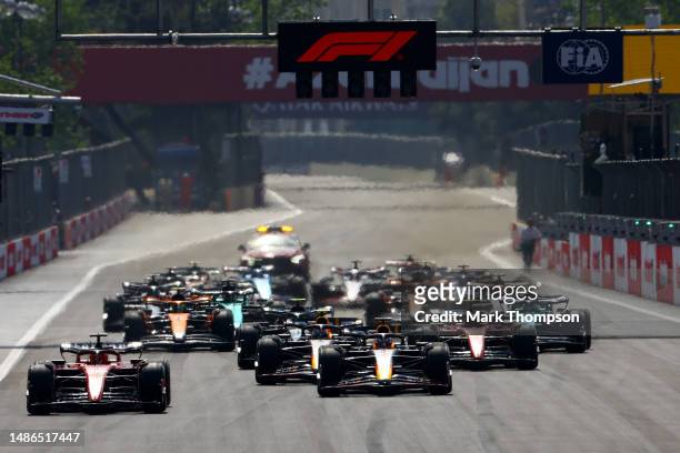 Charles Leclerc of Monaco driving the Ferrari SF-23 leads Max Verstappen of the Netherlands driving the Oracle Red Bull Racing RB19 and the rest of...