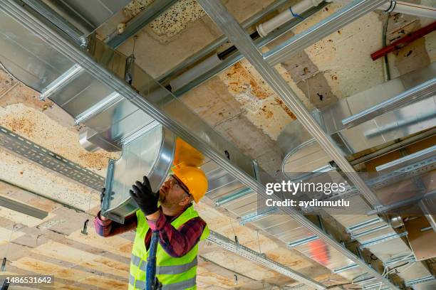 travailleur manuel installant un climatiseur dans le bâtiment. - climatiseur photos et images de collection