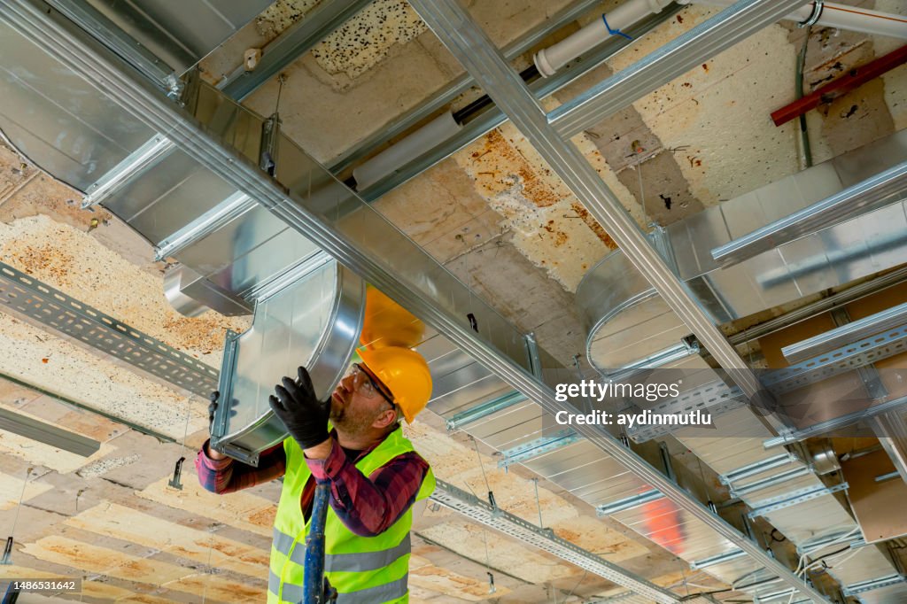 Manual Worker installing air conditioner in building.