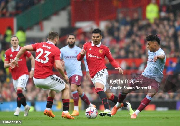 Luke Shaw and Casemiro of Manchester United are challenged by Ollie Watkins of Aston Villa during the Premier League match between Manchester United...
