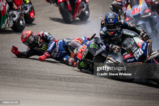 Fabio Quartararo of France and Monster Energy Yamaha MotoGP crashes into Miguel Oliveira of Portugal and CryptoDATA RNF MotoGP Team at turn two...