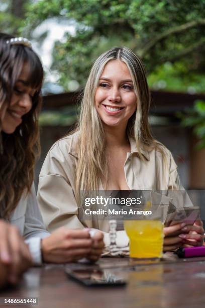 group of friends enjoy each other's company while waiting for their food to be brought to them at the vegan restaurant - annual companions stock pictures, royalty-free photos & images