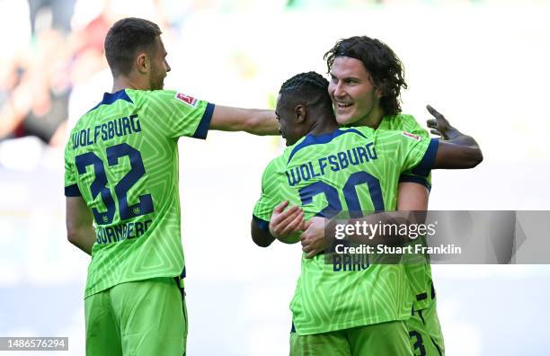 Jonas Wind of VfL Wolfsburg celebrates with teammate Ridle Baku after scoring the team's third goal during the Bundesliga match between VfL Wolfsburg...