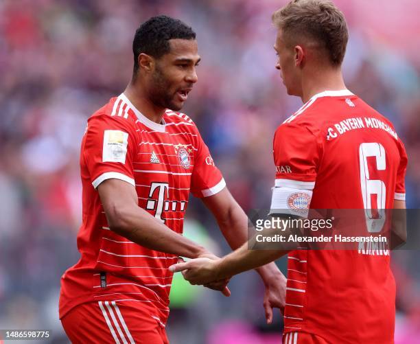 Serge Gnabry of FC Bayern Munich celebrates with teammate Joshua Kimmich after scoring the team's first goal during the Bundesliga match between FC...