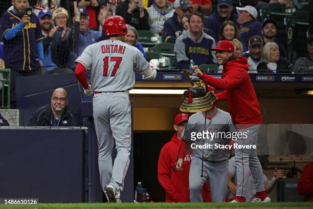 Shohei Ohtani of the Los Angeles Angels is congratulated by Brett Phillips following a home run against the Milwaukee Brewers during the third inning...