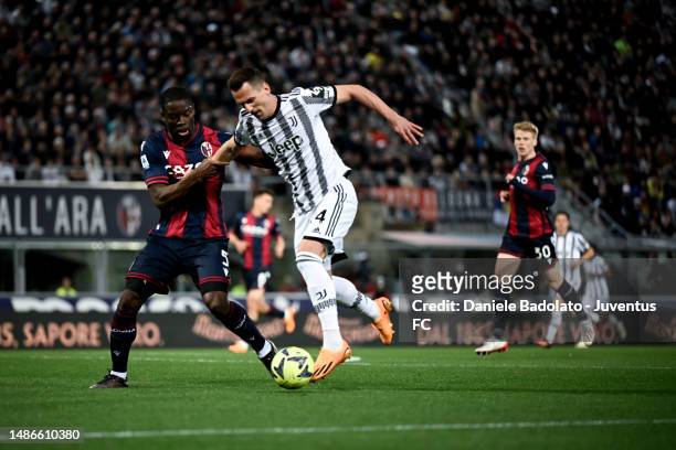 Arkadiusz Krystian Milik of Juventus battles for the ball with Adamo Soumaoro of Bologna FC during the Serie A match between Bologna FC and Juventus...