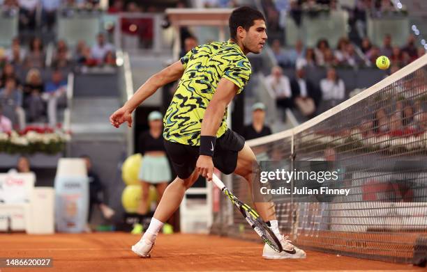 Carlos Alcarez of Spain avoids touching the net after playing a shot against Grigor Dimitrov of Bulgaria during the men's third round match on Day...