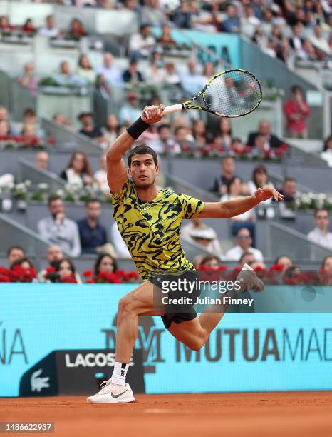 Carlos Alcarez of Spain in action against Grigor Dimitrov of Bulgaria during the men's third round match on Day Seven of the Mutua Madrid Open at La...