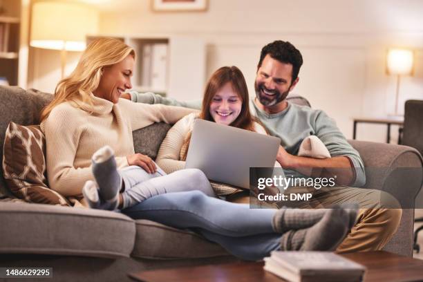 famille heureuse sur canapé avec ordinateur portable, sourire et streaming vidéo en ligne avec du temps de qualité pour se détendre la nuit à la maison. père, mère et fille sur le canapé ensemble dans le bonheur, le web et la liaison avec les films - family smile photos et images de collection
