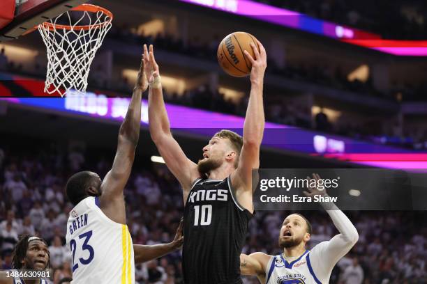 Domantas Sabonis of the Sacramento Kings drives to the basket against Draymond Green of the Golden State Warriors during the second quarter in game...