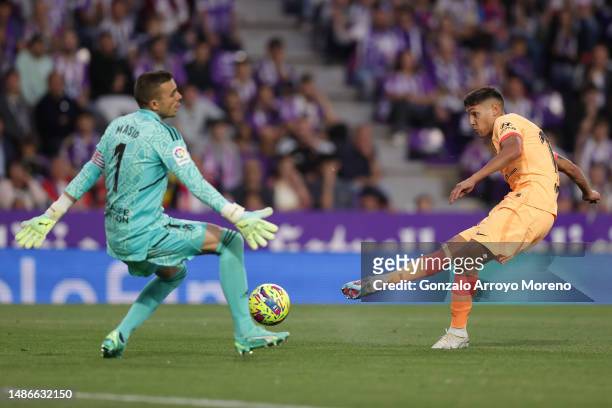 Nahuel Molina of Atletico de Madrid scores their opening goal defeating goalkeeper Jordi Masip of Real Valladolid CF during the LaLiga Santander...