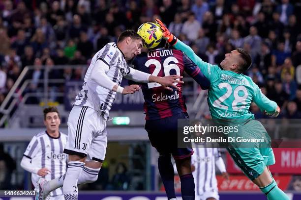 Dusan Vlahovic of Juventus FC competes for the ball with Jhon Lucumi of Bologna FC and Lukasz Skorupski of Bologna FC during the Serie A match...