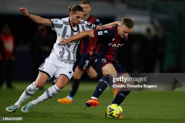 Adrien Rabiot of Juventus challenges Lewis Ferguson of Bologna during the Serie A match between Bologna FC and Juventus at Stadio Renato Dall'Ara on...