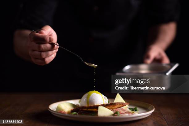 a male chef pouring sauce on a plate of carpaccio with burrata cheese - burrata stock pictures, royalty-free photos & images