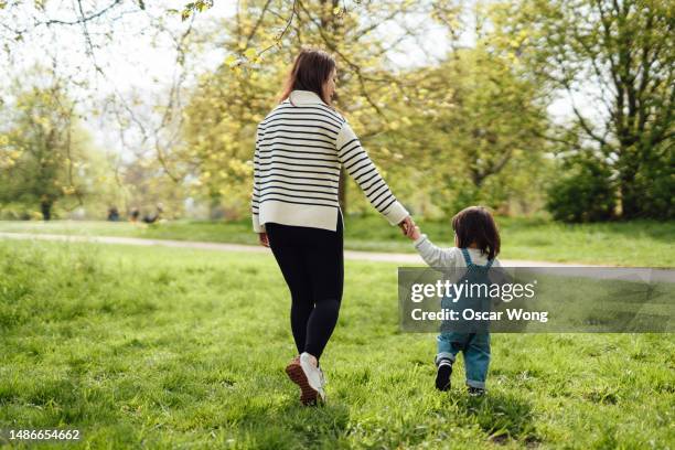 young asian mother enjoying family time with her toddler in nature - park stock pictures, royalty-free photos & images