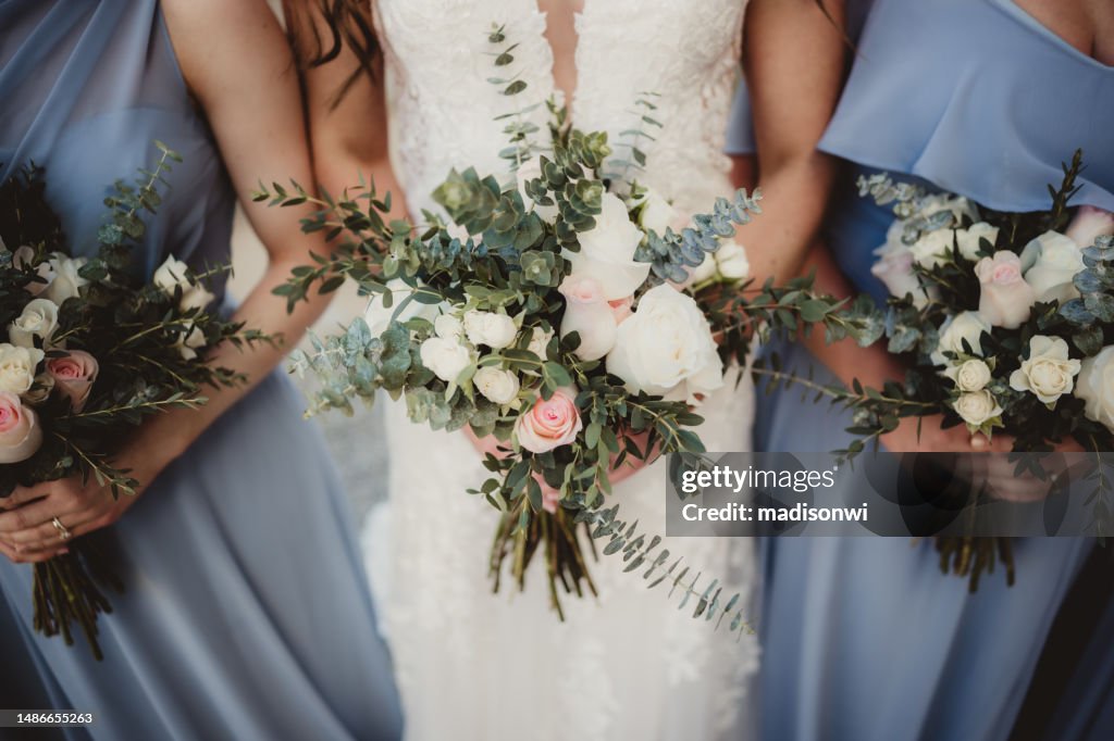 Bride and bridesmaids holding bouquets of flowers