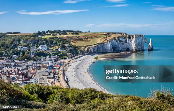 beach and town of étretat with view of the chalk cliff of falaise d'aval on the alabaster coast with  the natural arch of porte d'aval and the l'aiguille rock needle, pays de caux, seine-maritime, normandy, france - ポルトダヴァル ストックフォトと画像