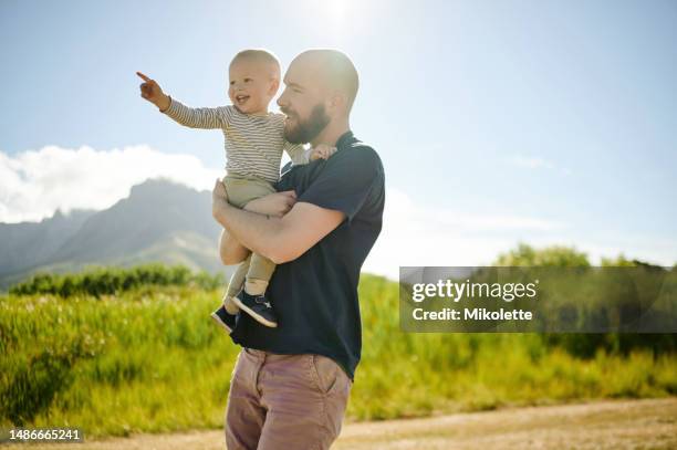 baby, pointing and father walking in a field, happy and bonding in nature with love. hug, carrying and parent with child in the countryside for fun, travel and vacation, walk and learning in mexico - baby pointing stock pictures, royalty-free photos & images