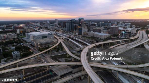 aerial view of downtown orlando over the huge transport junction with highways, and multiple overpasses in the early morning at sunrise. - downtown orlando stock pictures, royalty-free photos & images