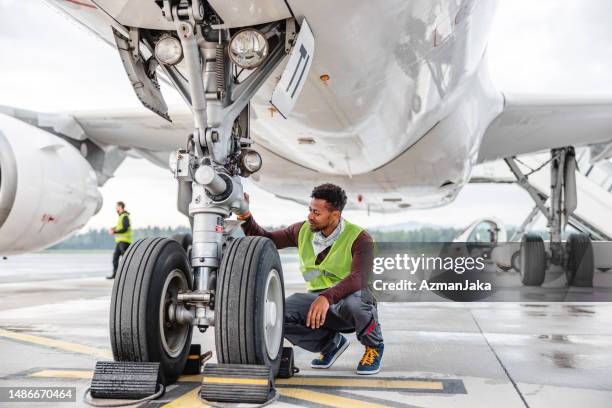 aircraft mechanic maintaining jet airplane - airport cargo stock pictures, royalty-free photos & images