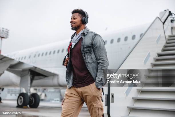 ein afroamerikaner steigt aus dem flugzeug - boarding plane stock-fotos und bilder