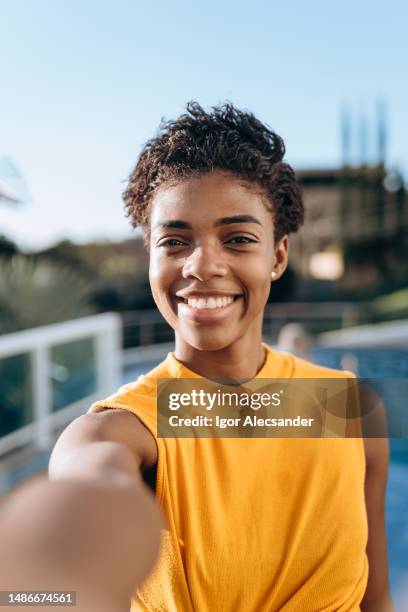 young woman taking a selfie - selfie imagens e fotografias de stock