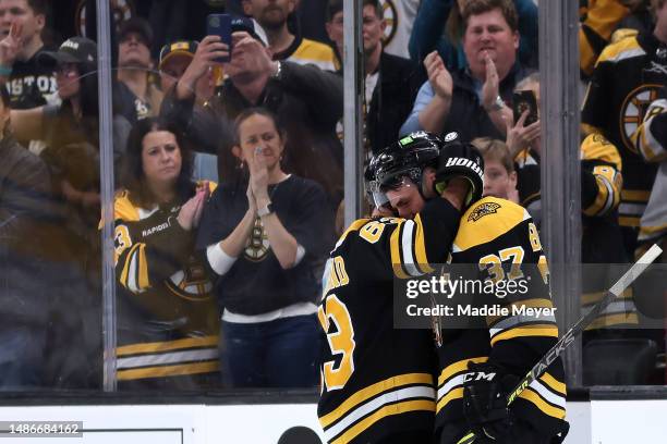 Patrice Bergeron of the Boston Bruins hugs Brad Marchand before exiting the ice after Florida Panthers defeat the Bruins 4-3 in overtime of Game...